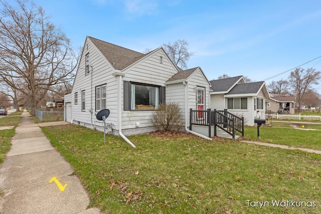 1193 E Apple Ave, Muskegon, MI 49442 - bungalow-style house with a front yard, fence, and roof with shingles