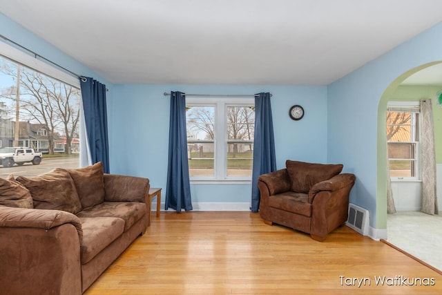1193 E Apple Ave, Muskegon, MI 49442 - living area featuring arched walkways, plenty of natural light, visible vents, and light wood-style floors