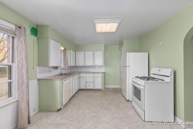 1193 E Apple Ave, Muskegon, MI 49442 - kitchen featuring white appliances, light countertops, backsplash, arched walkways, and a sink