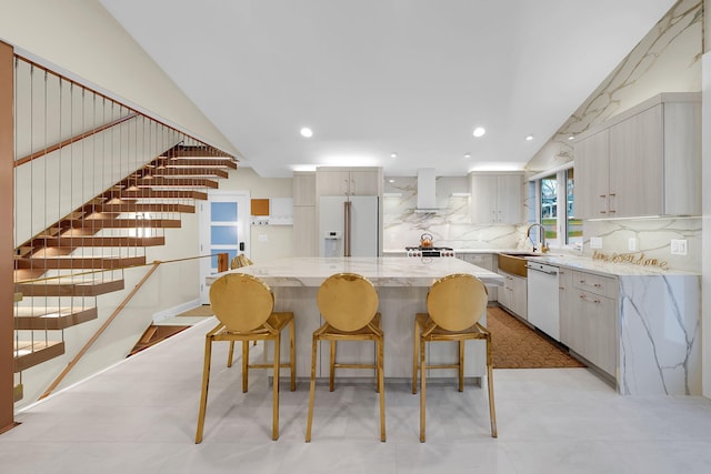 kitchen with wall chimney exhaust hood, white appliances, a sink, lofted ceiling, and backsplash