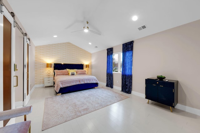bedroom featuring baseboards, an accent wall, a barn door, recessed lighting, and vaulted ceiling
