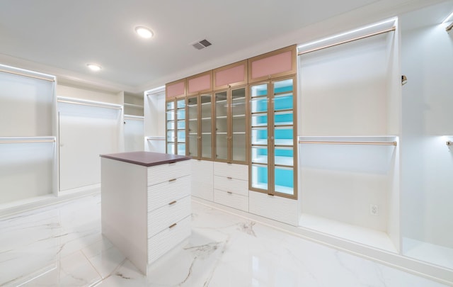 walk in closet with visible vents and marble finish floor