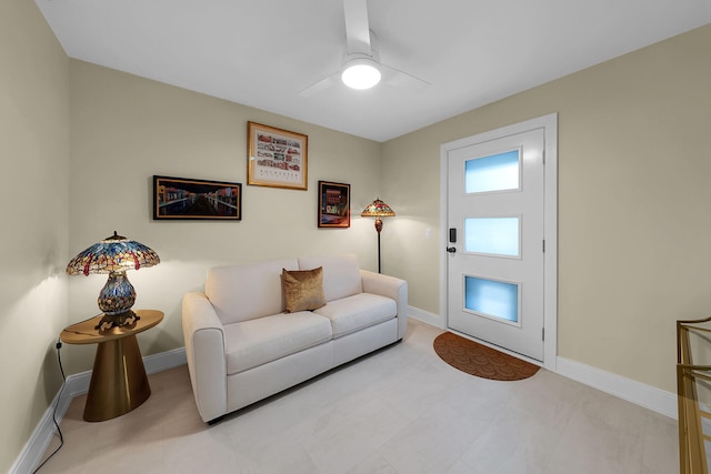 living room with baseboards and a ceiling fan