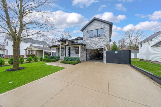 view of front of home featuring a front yard, driveway, stone siding, and an attached garage