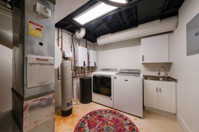 laundry room featuring separate washer and dryer, tankless water heater, electric panel, cabinet space, and a sink