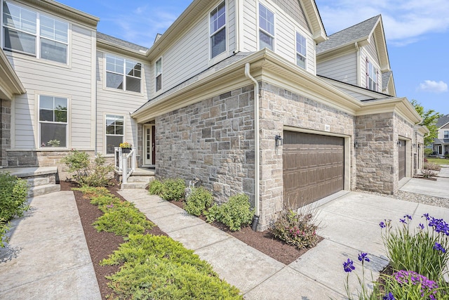 3092 N Spurway Dr, Ann Arbor, MI 48105 - view of property exterior with stone siding, a garage, and concrete driveway