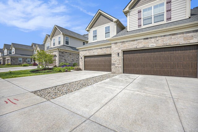 3092 N Spurway Dr, Ann Arbor, MI 48105 - view of front of house featuring a garage, driveway, stone siding, a residential view, and roof with shingles