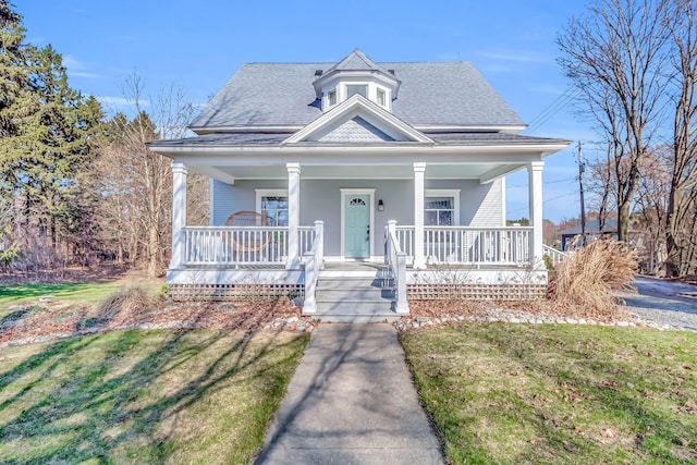 1856 N 56th Ave, Mears, MI 49436 - view of front of home with roof with shingles, a porch, and a front lawn