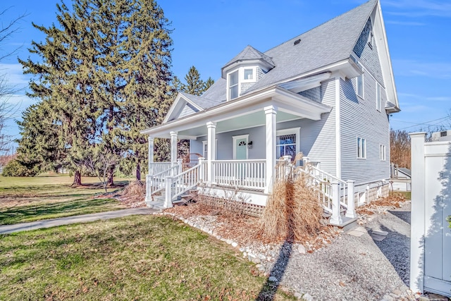 1856 N 56th Ave, Mears, MI 49436 - view of front of property with covered porch, a shingled roof, and a front lawn