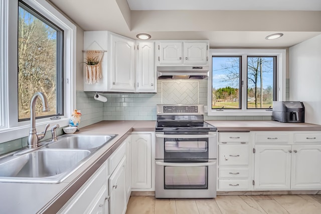 1856 N 56th Ave, Mears, MI 49436 - kitchen with double oven range, under cabinet range hood, plenty of natural light, and white cabinets