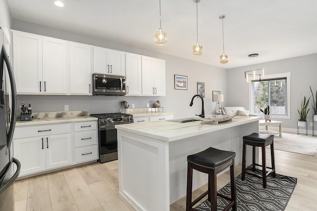 2128 Sampson Ave, Muskegon, MI 49441 - kitchen featuring stainless steel appliances, a kitchen bar, white cabinets, a kitchen island with sink, and recessed lighting