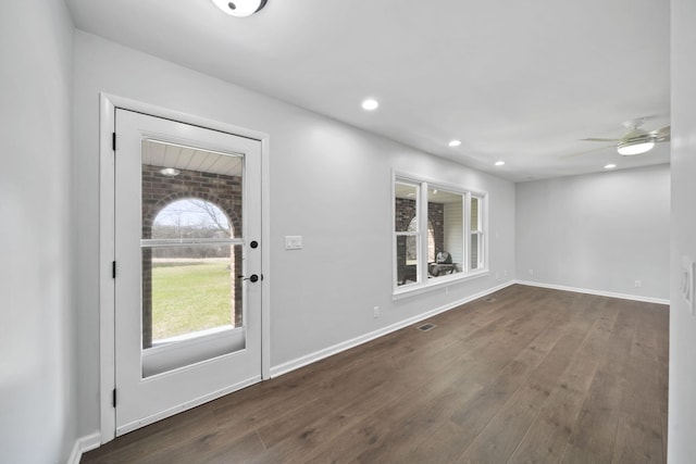 foyer entrance featuring visible vents, baseboards, wood finished floors, and ceiling fan