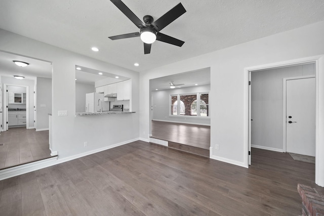 unfurnished living room featuring recessed lighting, dark wood finished floors, a ceiling fan, and baseboards