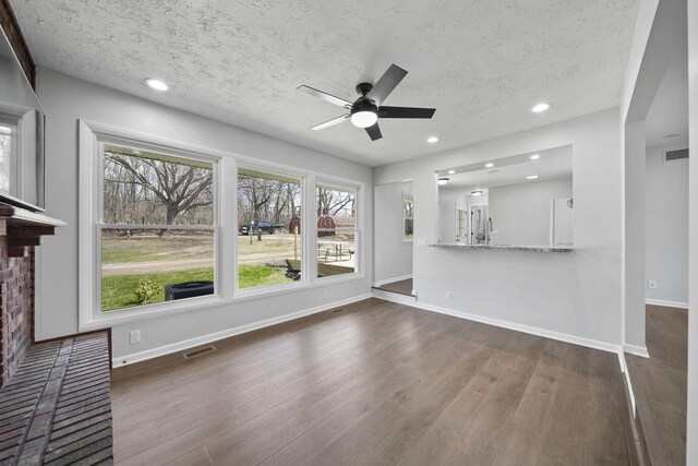 unfurnished living room with ceiling fan, a textured ceiling, and visible vents