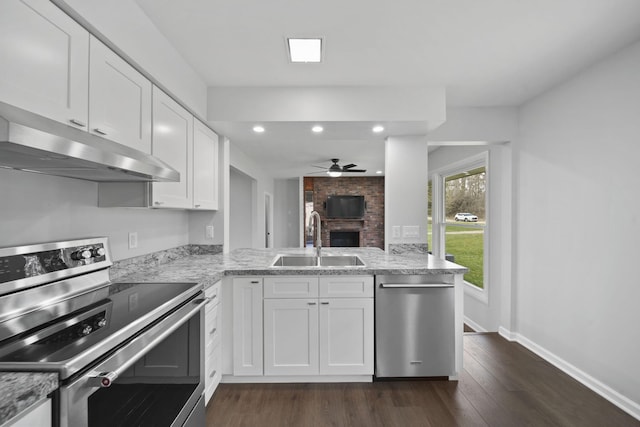 kitchen featuring stainless steel appliances, a peninsula, a sink, a ceiling fan, and under cabinet range hood