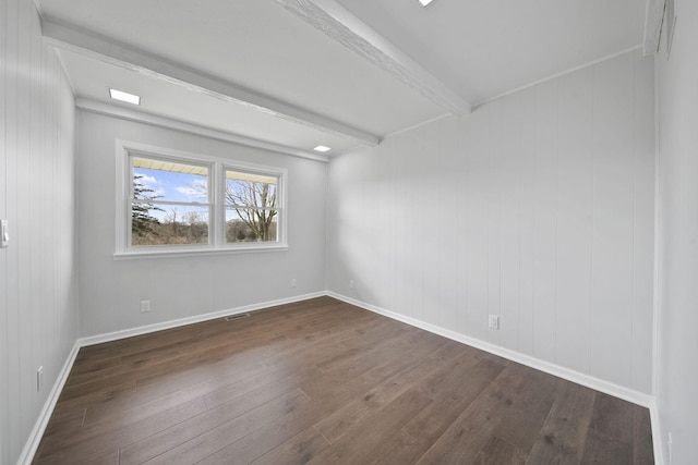 empty room featuring baseboards, visible vents, beam ceiling, and dark wood-type flooring
