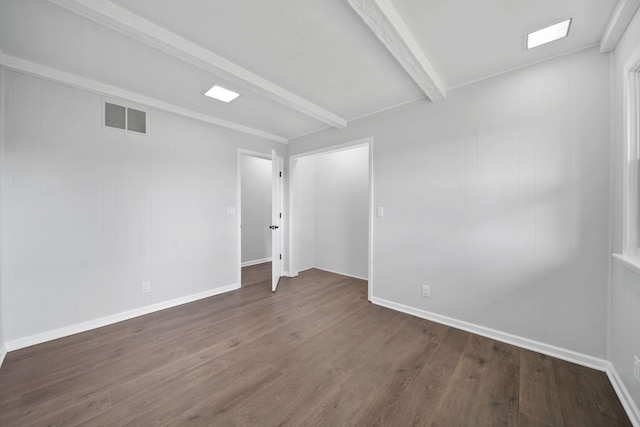 unfurnished room featuring dark wood finished floors, baseboards, beamed ceiling, and visible vents