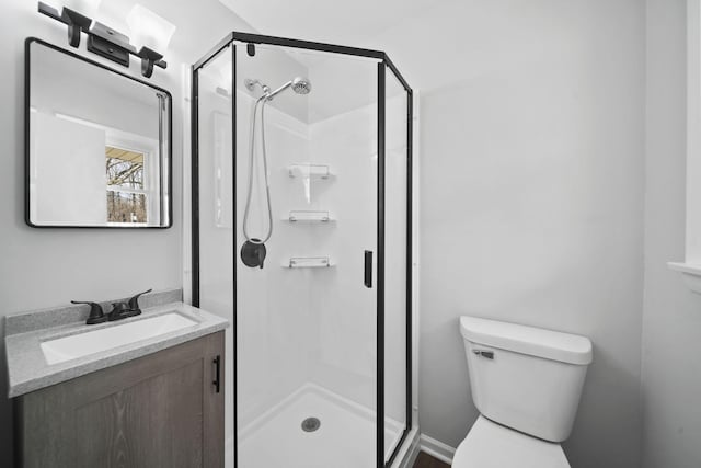 full bathroom with vanity, a shower stall, and toilet