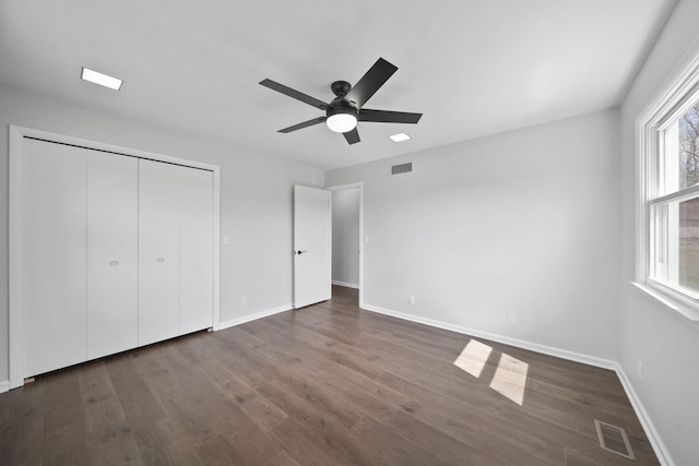 unfurnished bedroom with dark wood finished floors, visible vents, and baseboards