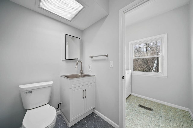 bathroom featuring visible vents, toilet, baseboards, and vanity