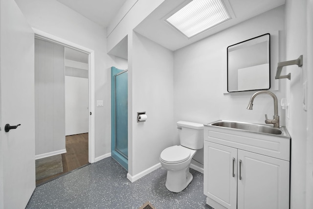 bathroom featuring toilet, baseboards, vanity, and a stall shower