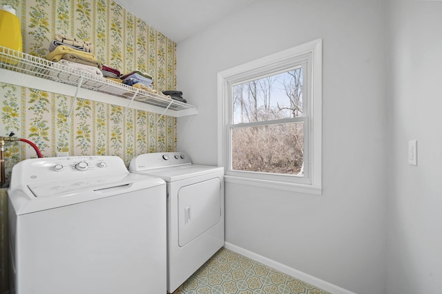 washroom featuring baseboards, wallpapered walls, washer and clothes dryer, and laundry area