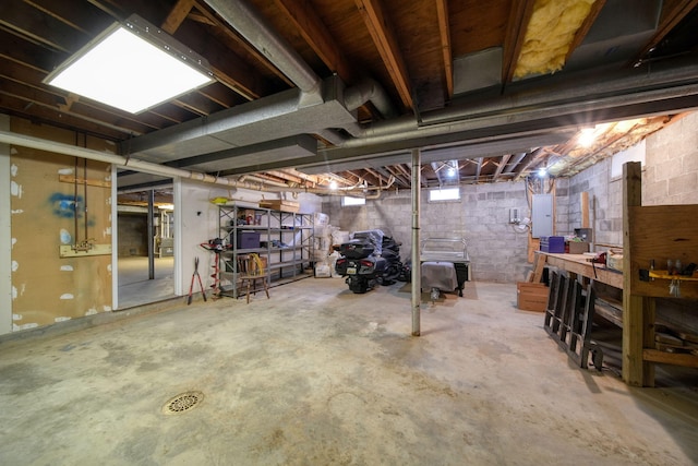 unfinished basement featuring a workshop area and electric panel