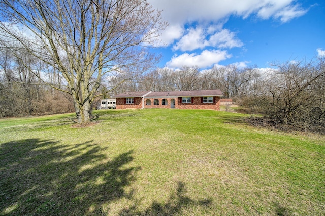 view of front facade with brick siding and a front yard