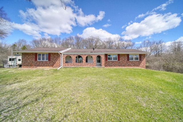 ranch-style house with covered porch, a front yard, and brick siding