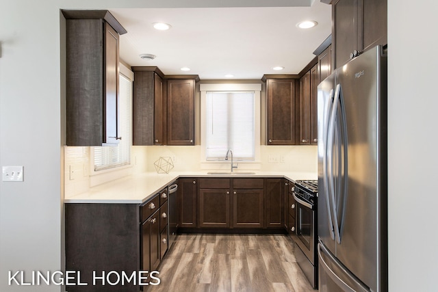 920 W Savidge St Unit 14, Spring Lake, MI 49456 - kitchen featuring appliances with stainless steel finishes, dark brown cabinetry, light wood-style flooring, light countertops, and recessed lighting