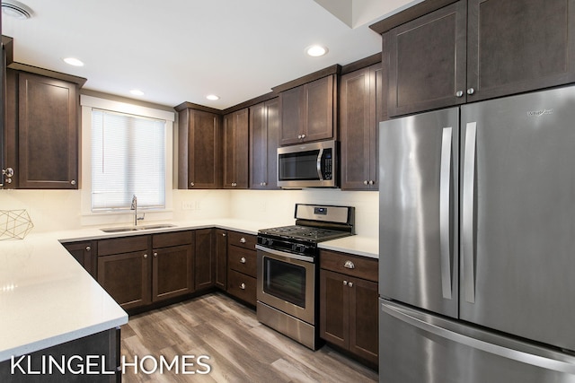 920 W Savidge St Unit 14, Spring Lake, MI 49456 - kitchen featuring appliances with stainless steel finishes, dark brown cabinets, wood finished floors, light countertops, and recessed lighting