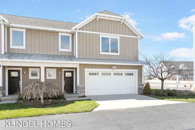 920 W Savidge St Unit 14, Spring Lake, MI 49456 - view of front of property featuring driveway, an attached garage, a metal roof, board and batten siding, and covered porch