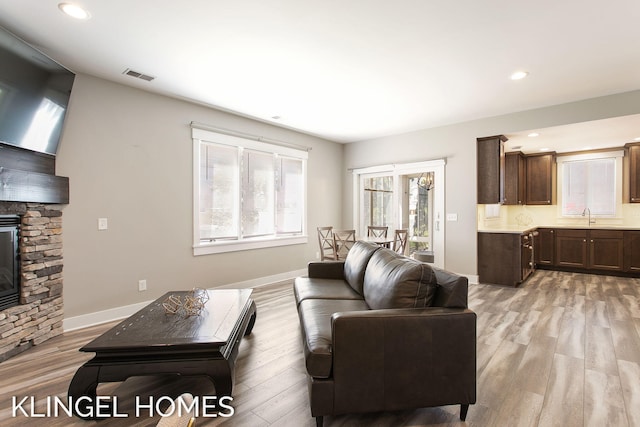 920 W Savidge St Unit 14, Spring Lake, MI 49456 - living room featuring light wood-style flooring, a stone fireplace, and recessed lighting