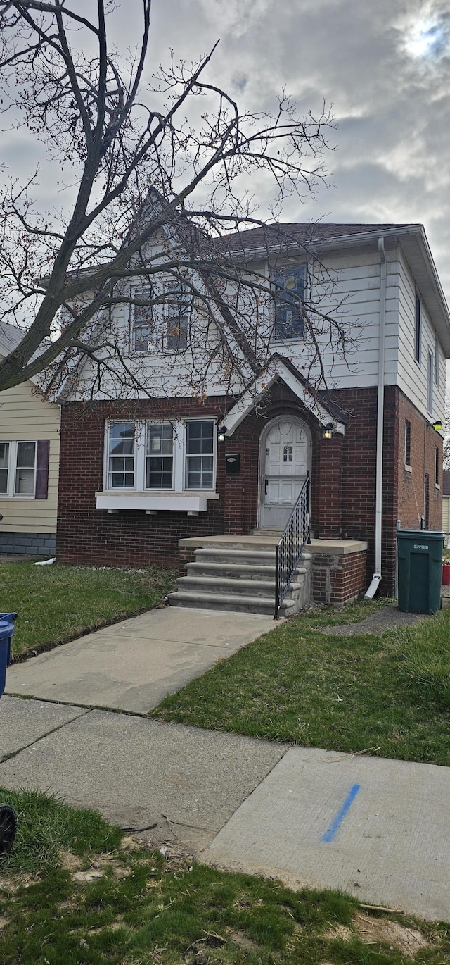 view of front of home featuring brick siding and a front yard