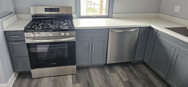 kitchen with gray cabinets, light countertops, appliances with stainless steel finishes, and dark wood finished floors