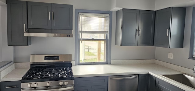 kitchen featuring a sink, light countertops, appliances with stainless steel finishes, under cabinet range hood, and gray cabinetry