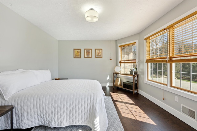7101 River Glen Dr, Caledonia, MI 49316 - bedroom with visible vents, baseboards, wood finished floors, and a textured ceiling