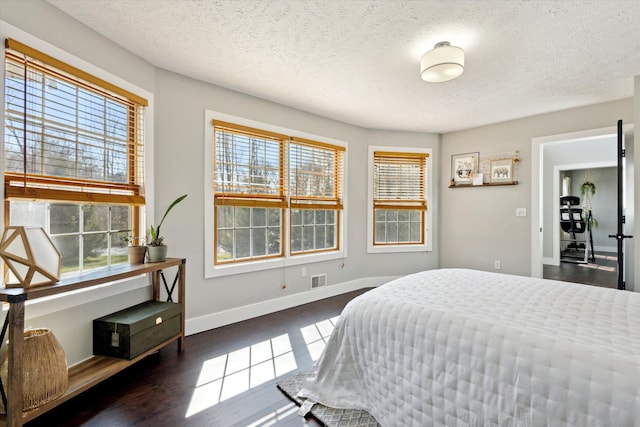 7101 River Glen Dr, Caledonia, MI 49316 - bedroom with a textured ceiling, baseboards, dark wood finished floors, and visible vents