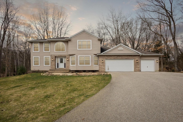 7101 River Glen Dr, Caledonia, MI 49316 - view of front of house with a garage, aphalt driveway, and a front lawn
