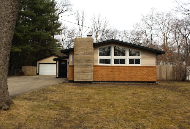 mid-century home featuring a garage, a chimney, fence, brick siding, and a front lawn