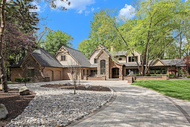2891 Gale Rd, Ann Arbor, MI 48105 - view of front facade featuring stone siding, curved driveway, a chimney, and a front yard