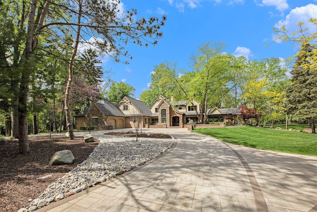 2891 Gale Rd, Ann Arbor, MI 48105 - view of front of home with stone siding, a front yard, and curved driveway