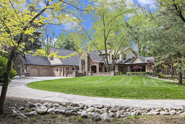 2891 Gale Rd, Ann Arbor, MI 48105 - back of house featuring stone siding, a yard, a garage, and driveway