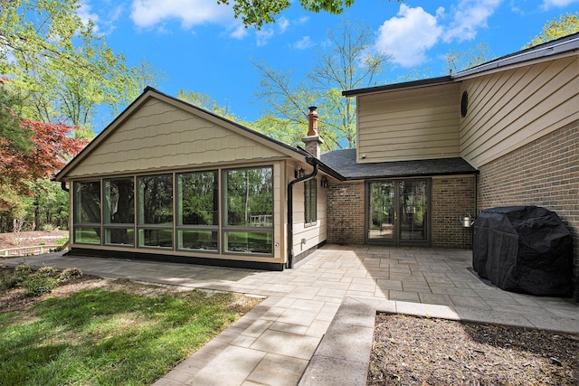 2891 Gale Rd, Ann Arbor, MI 48105 - rear view of house with a patio, brick siding, a sunroom, and roof with shingles