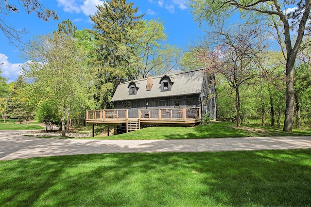 2891 Gale Rd, Ann Arbor, MI 48105 - view of front of house featuring a deck, a front lawn, a chimney, and metal roof