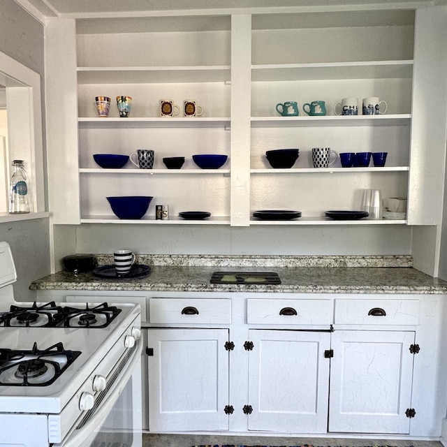 4830 Deep Point Dr, Portage, MI 49002 - kitchen featuring white gas range oven, open shelves, white cabinetry, and light stone countertops