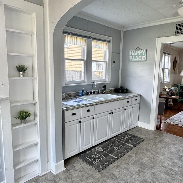 4830 Deep Point Dr, Portage, MI 49002 - kitchen with a sink, crown molding, white cabinets, arched walkways, and tile patterned floors