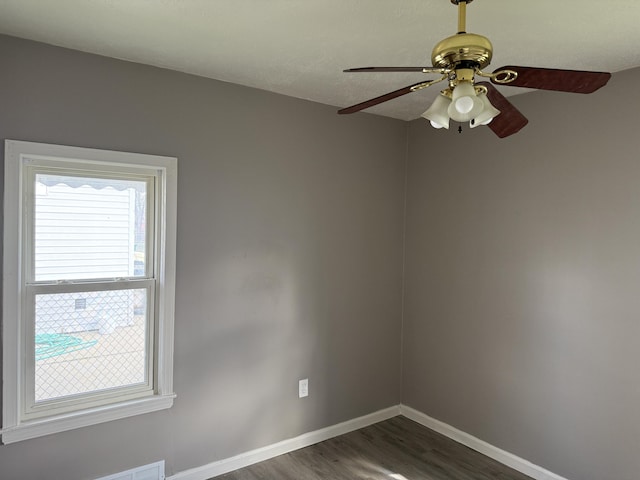 empty room featuring dark wood-type flooring, ceiling fan, and baseboards