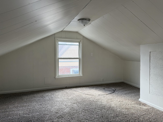 additional living space featuring vaulted ceiling and carpet floors