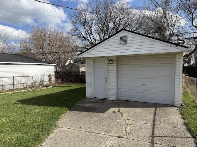 detached garage featuring fence and driveway
